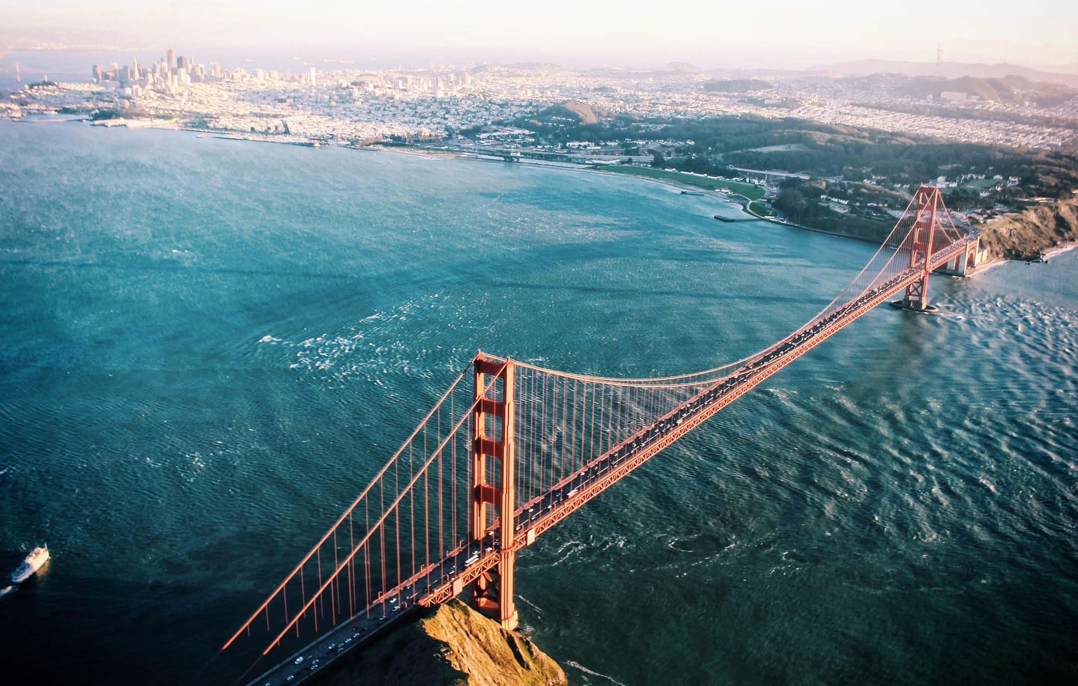 The full Golden Gate Bridge seen from above and to the left, with San Francisco across the water